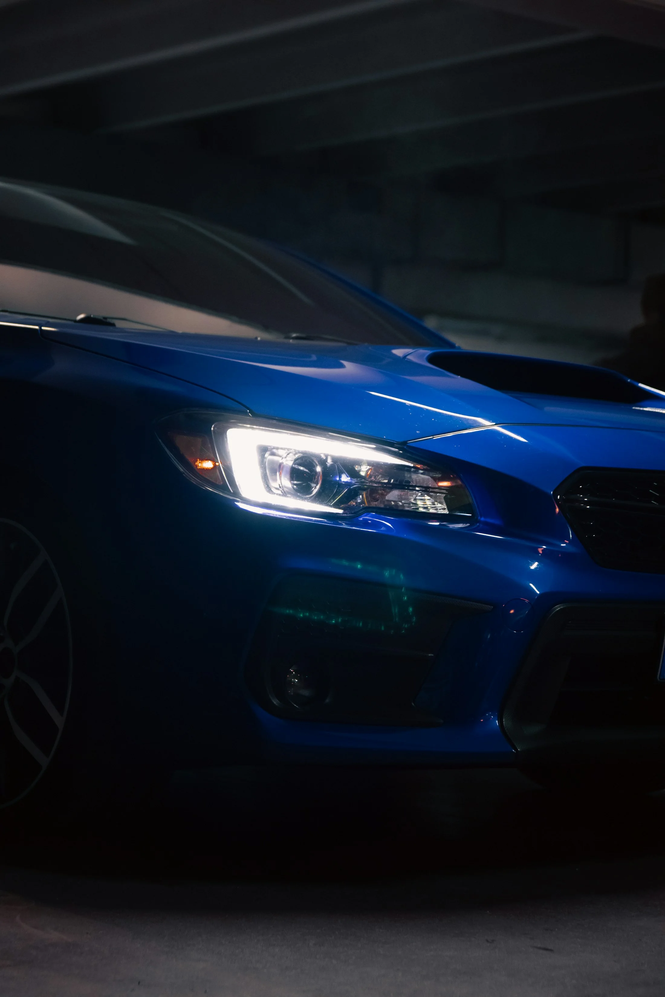 Front eines dunkelblauen Fahrzeugs in einer Werkstatt